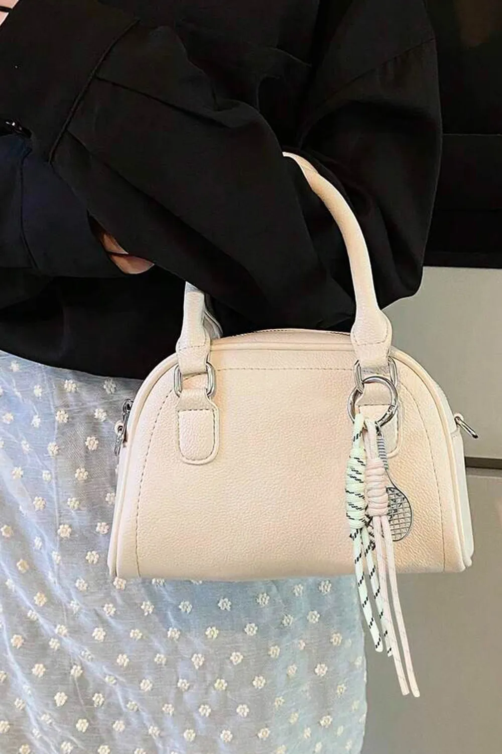 حقيبة يد بتصميم نصف دائري يزينها وشاح مربوط