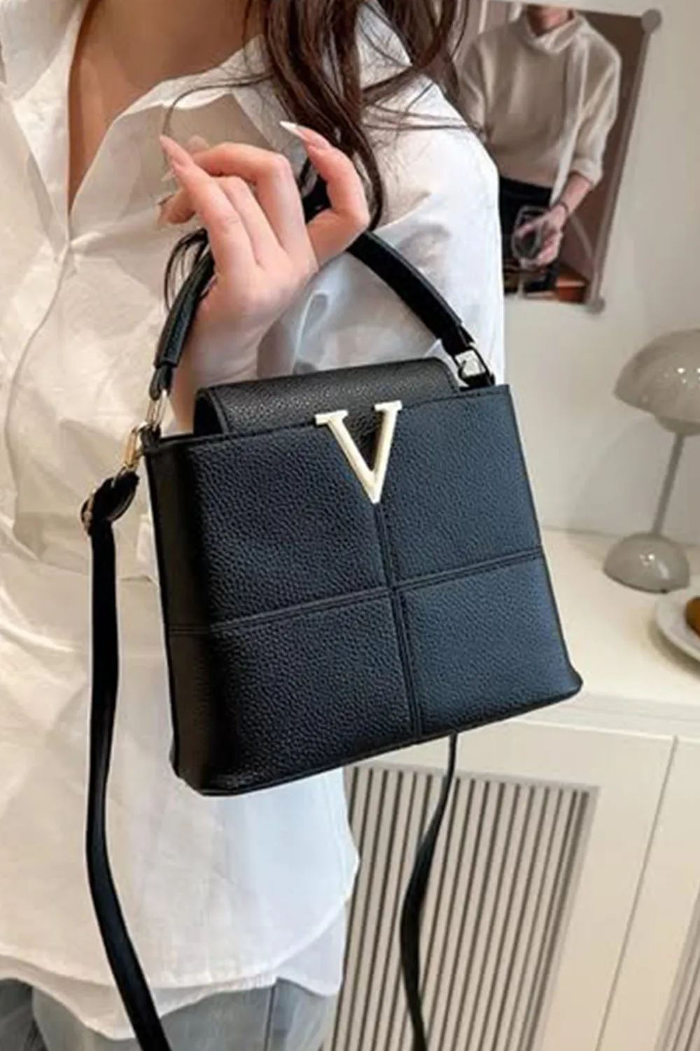 حقيبة يد نسائية مع زخرفة معدنية على شكل حرف "V" في المقدمة